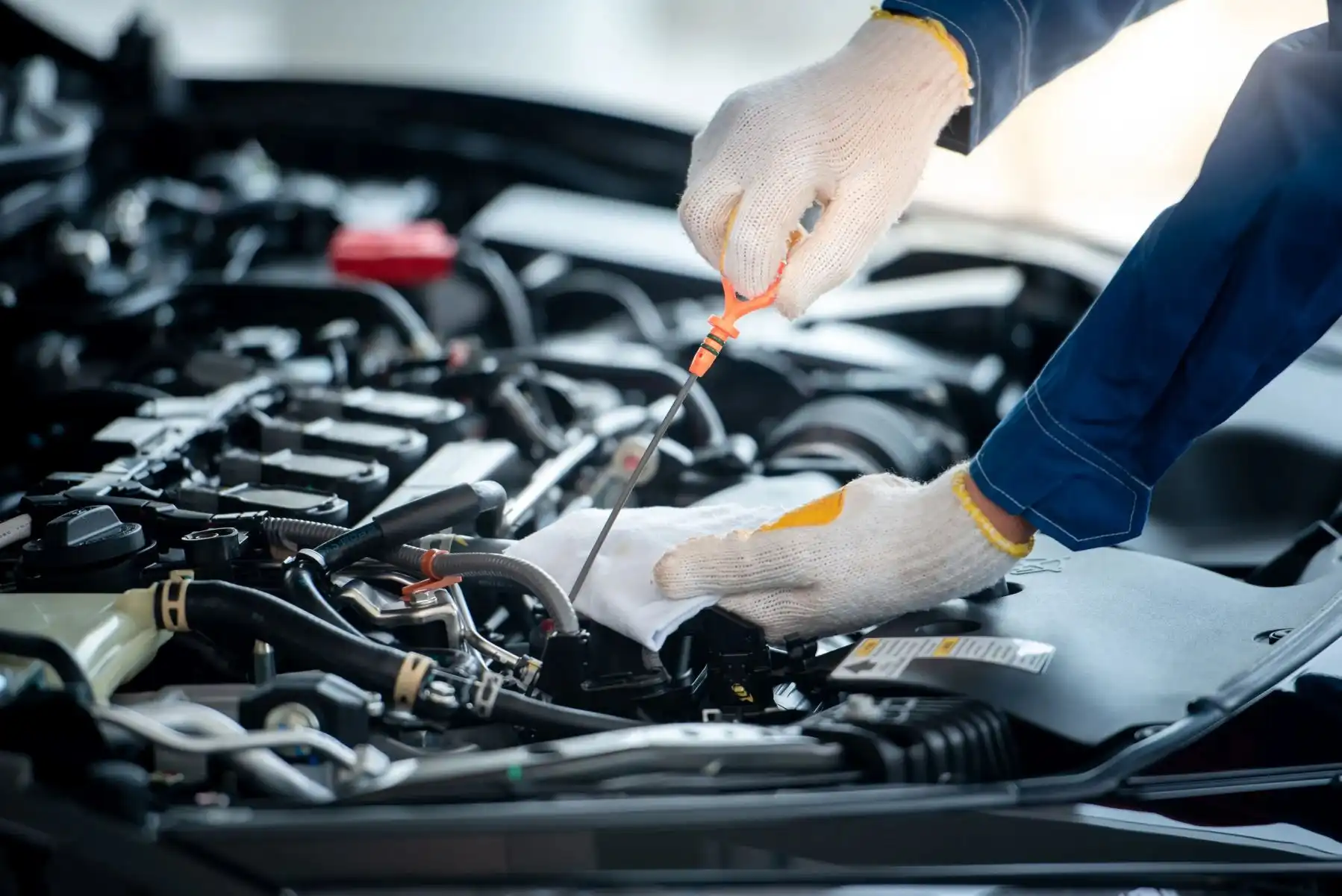 Ein Automechaniker in einer Autowerkstatt überprüft den Motor.
